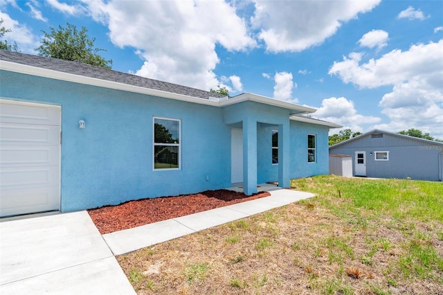 21480 Eldred Ave, Port Charlotte, FL 33952 - view of front of house with stucco siding, a front yard, and a shingled roof
