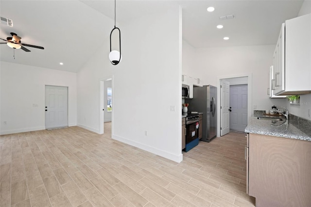 21480 Eldred Ave, Port Charlotte, FL 33952 - kitchen featuring stainless steel appliances, a sink, open floor plan, a ceiling fan, and high vaulted ceiling