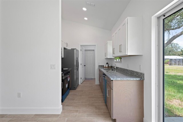 21480 Eldred Ave, Port Charlotte, FL 33952 - kitchen featuring appliances with stainless steel finishes, white cabinets, light stone countertops, a sink, and light wood-type flooring