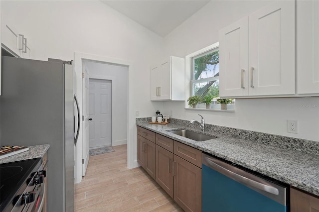 21480 Eldred Ave, Port Charlotte, FL 33952 - kitchen with stainless steel appliances, a sink, light stone counters, and white cabinets