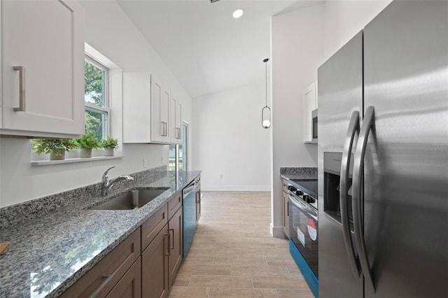21480 Eldred Ave, Port Charlotte, FL 33952 - kitchen featuring stainless steel appliances, a sink, dark stone countertops, white cabinetry, and light wood finished floors