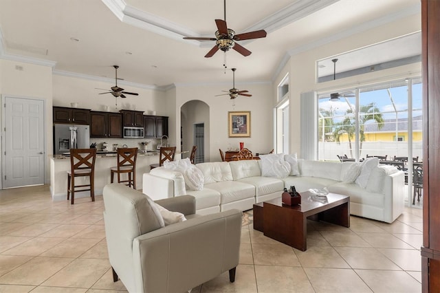 18652 Ohara Dr, Port Charlotte, FL 33948 - living area featuring a raised ceiling, a ceiling fan, ornamental molding, light tile patterned flooring, and arched walkways