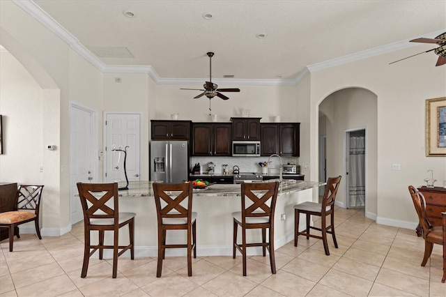 18652 Ohara Dr, Port Charlotte, FL 33948 - kitchen featuring crown molding, a breakfast bar, ceiling fan, arched walkways, and stainless steel appliances
