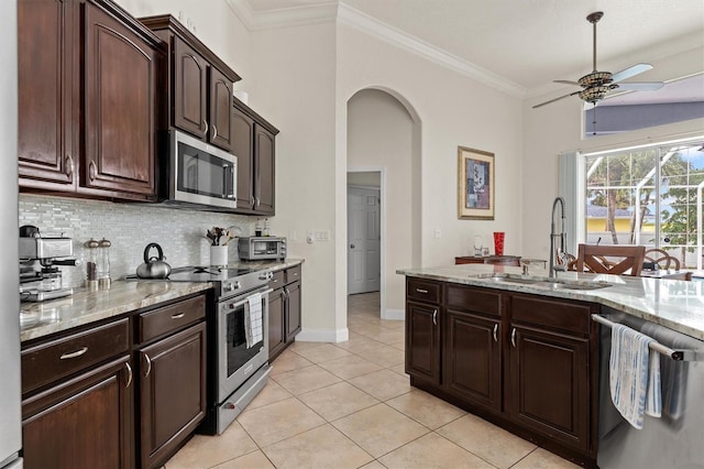 18652 Ohara Dr, Port Charlotte, FL 33948 - kitchen with a ceiling fan, a sink, arched walkways, backsplash, and appliances with stainless steel finishes