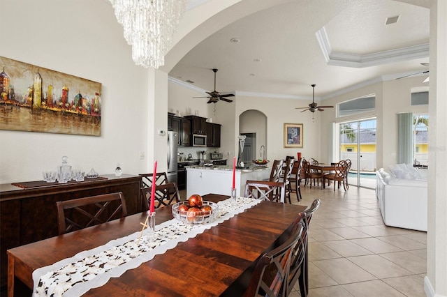 18652 Ohara Dr, Port Charlotte, FL 33948 - dining area with arched walkways, visible vents, ceiling fan with notable chandelier, crown molding, and light tile patterned floors