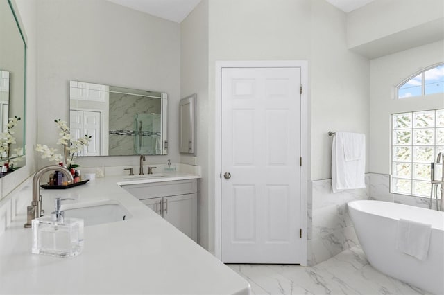18652 Ohara Dr, Port Charlotte, FL 33948 - full bathroom with a freestanding bath, marble finish floor, a sink, and a wainscoted wall