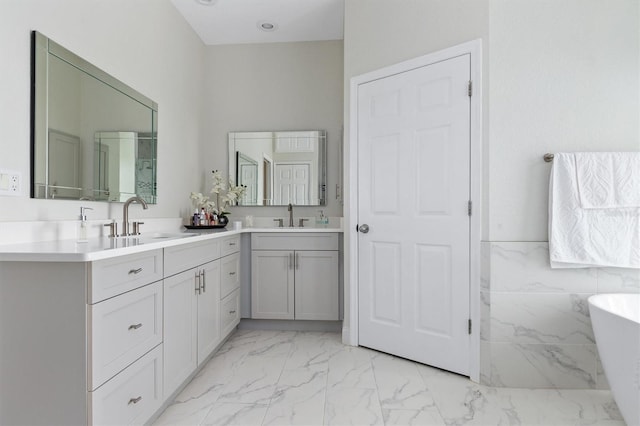 18652 Ohara Dr, Port Charlotte, FL 33948 - bathroom with double vanity, a freestanding tub, marble finish floor, and a sink
