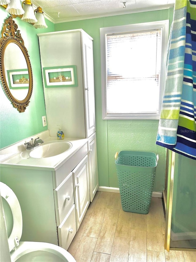 full bath featuring wood finished floors, vanity, and crown molding