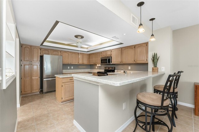 1750 Jamaica Way Unit 312, Punta Gorda, FL 33950 - kitchen with stainless steel appliances, light countertops, a peninsula, visible vents, and a raised ceiling