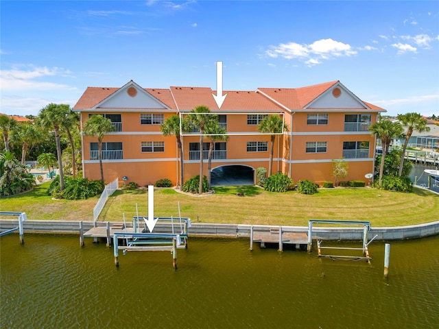 view of dock featuring a lawn, boat lift, and a water view
