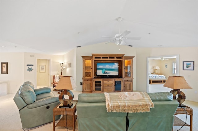 carpeted living room featuring baseboards, ceiling fan, and vaulted ceiling