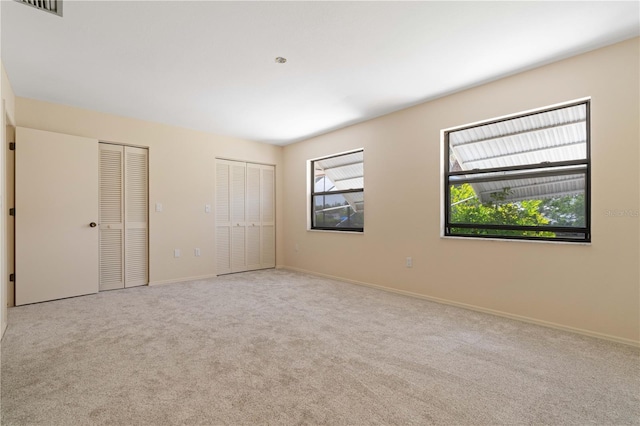 453 Carolyn Ln, Punta Gorda, FL 33950 - unfurnished bedroom featuring visible vents, carpet flooring, baseboards, and two closets