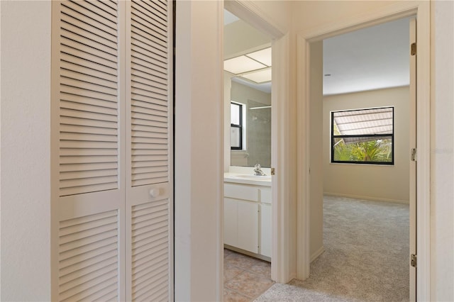 453 Carolyn Ln, Punta Gorda, FL 33950 - hall with light tile patterned floors, baseboards, light carpet, and a sink