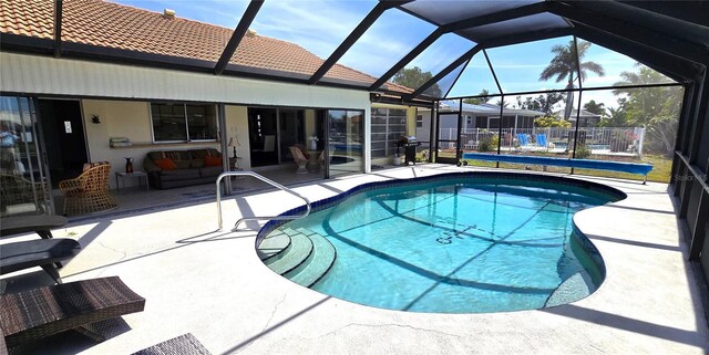 outdoor pool featuring a lanai and a patio area