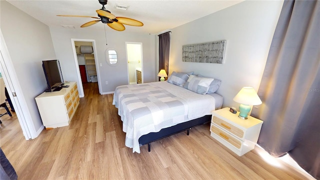 bedroom featuring visible vents, light wood finished floors, baseboards, and a ceiling fan