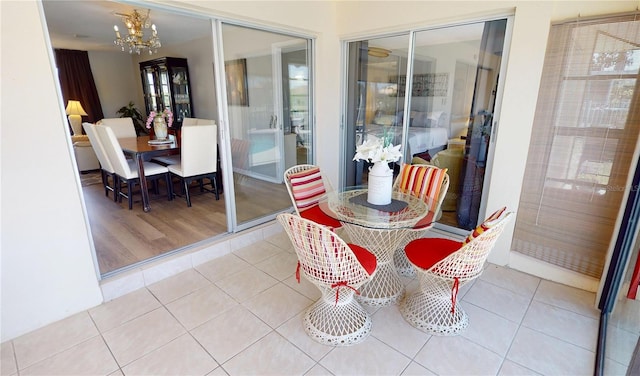tiled dining area featuring plenty of natural light and a chandelier