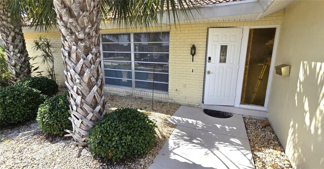 property entrance featuring brick siding and stucco siding