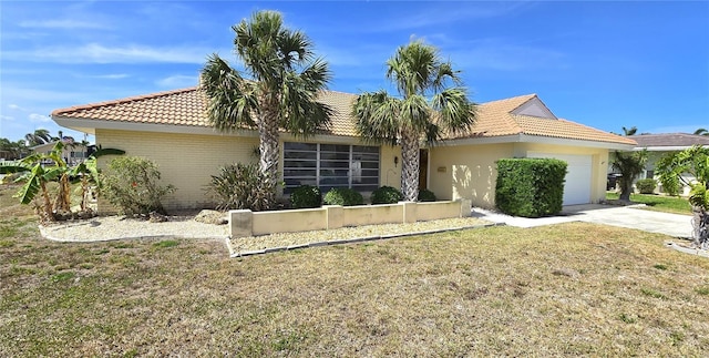 view of front of home featuring concrete driveway, a front lawn, a tiled roof, and a garage
