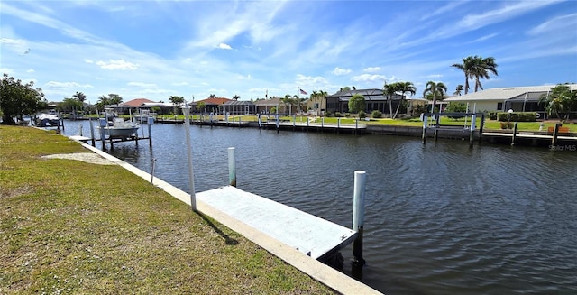 dock area with a lawn, a residential view, and a water view