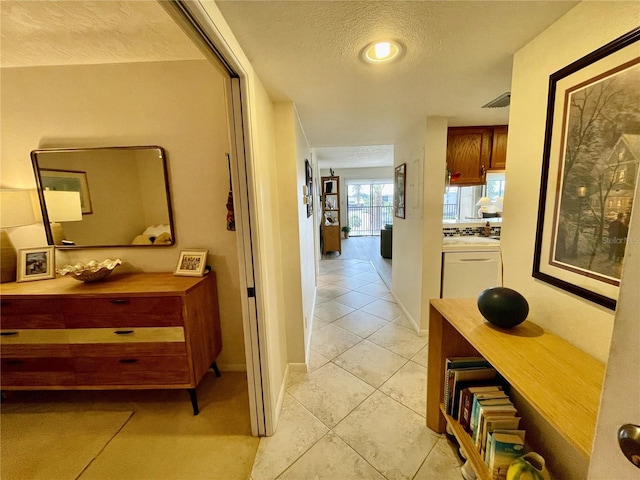 25188 Marion Ave Unit F304, Punta Gorda, FL 33950 - hall featuring baseboards, light tile patterned floors, and a textured ceiling