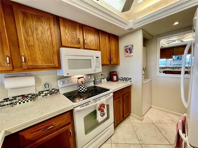 25188 Marion Ave Unit F304, Punta Gorda, FL 33950 - kitchen with light tile patterned floors, light countertops, brown cabinets, and white appliances