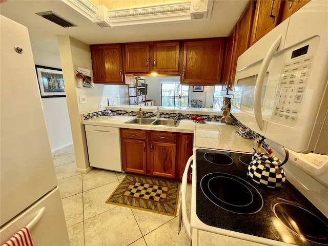25188 Marion Ave Unit F304, Punta Gorda, FL 33950 - kitchen with a sink, tile counters, visible vents, white appliances, and brown cabinetry