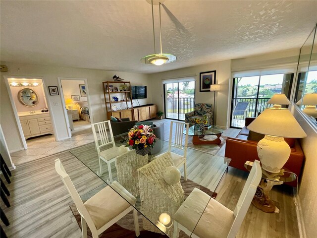 25188 Marion Ave Unit F304, Punta Gorda, FL 33950 - living area featuring a textured ceiling, light wood-style flooring, and baseboards