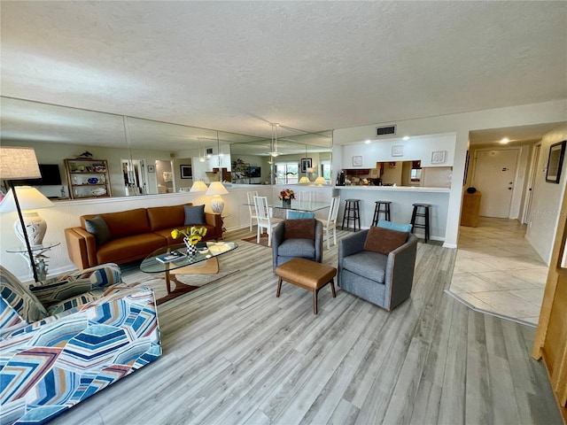 25188 Marion Ave Unit F304, Punta Gorda, FL 33950 - living area with a textured ceiling, visible vents, and wood finished floors