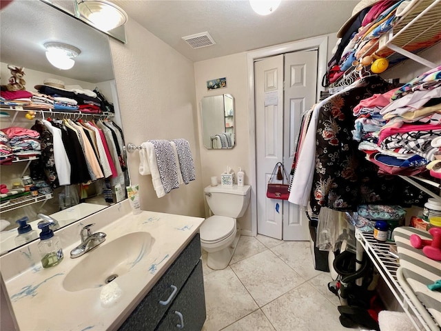 25188 Marion Ave Unit F304, Punta Gorda, FL 33950 - bathroom featuring tile patterned flooring, toilet, vanity, a walk in closet, and visible vents