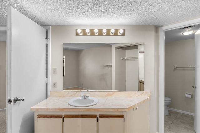 19505 Quesada Ave Unit A204, Port Charlotte, FL 33948 - bathroom with a textured ceiling, visible vents, toilet, vanity, and tile patterned flooring