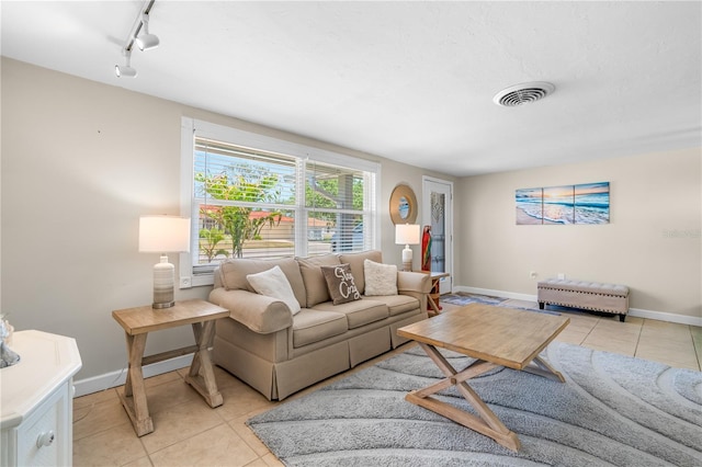 living area with light tile patterned floors, baseboards, rail lighting, and visible vents