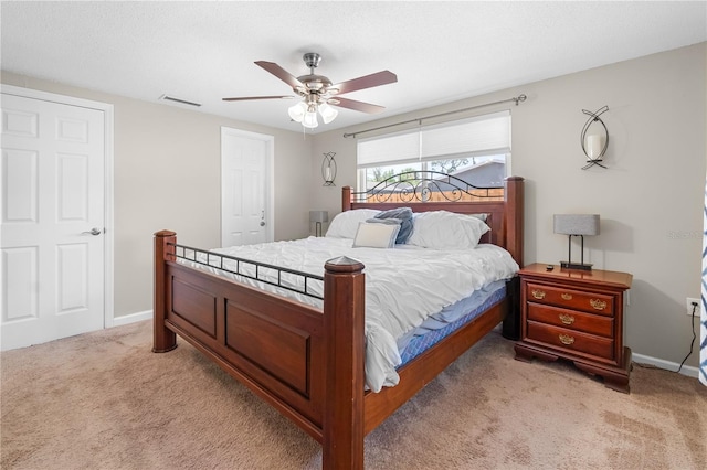 bedroom with baseboards, light colored carpet, ceiling fan, and visible vents
