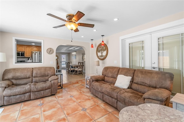 living room featuring ceiling fan, recessed lighting, french doors, arched walkways, and light tile patterned floors