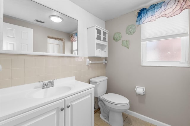 bathroom with visible vents, tile walls, tile patterned flooring, vanity, and toilet