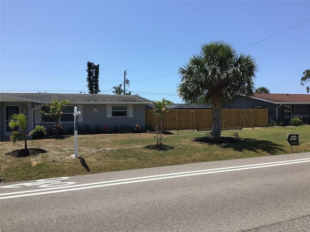 single story home featuring fence and a front lawn