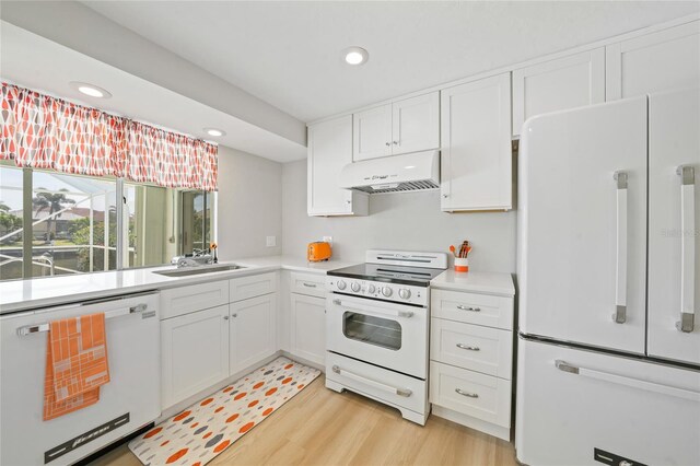 48 Hibiscus Dr, Punta Gorda, FL 33950 - kitchen with white appliances, under cabinet range hood, light countertops, a sink, and white cabinetry