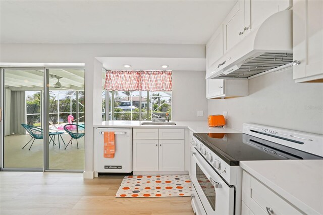 48 Hibiscus Dr, Punta Gorda, FL 33950 - kitchen with white appliances, exhaust hood, white cabinets, and light countertops