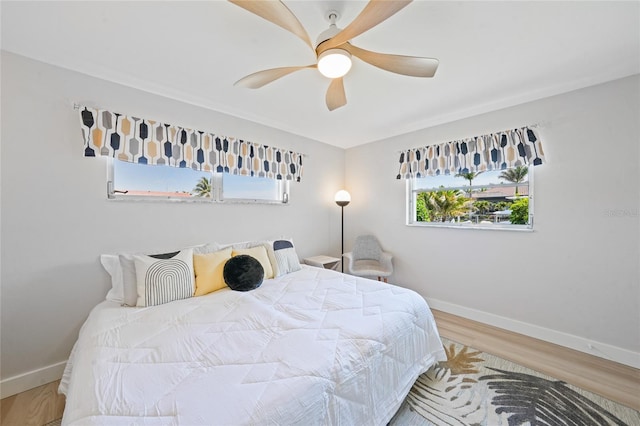 48 Hibiscus Dr, Punta Gorda, FL 33950 - bedroom with wood finished floors, baseboards, a ceiling fan, and multiple windows