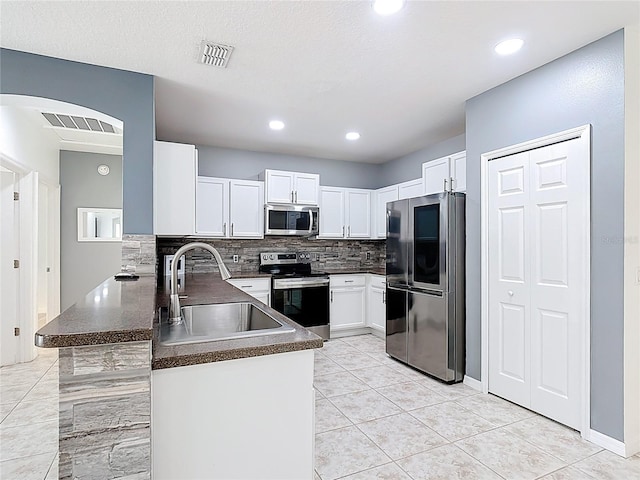3514 Yacht Club Ct, Kissimmee, FL 34746 - kitchen featuring stainless steel appliances, dark countertops, a sink, visible vents, and a peninsula