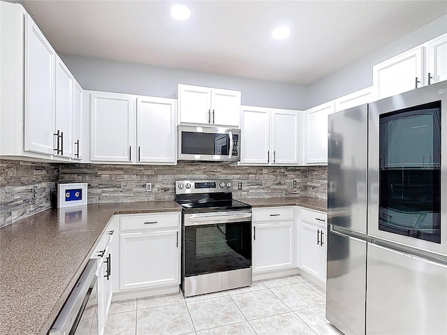 3514 Yacht Club Ct, Kissimmee, FL 34746 - kitchen featuring appliances with stainless steel finishes, dark countertops, decorative backsplash, and white cabinets