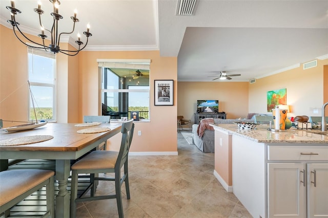 kitchen with visible vents, a healthy amount of sunlight, crown molding, and ceiling fan with notable chandelier