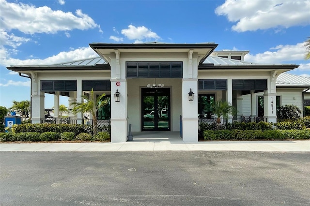 entrance to property featuring covered porch, a standing seam roof, and metal roof