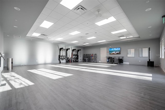 exercise area with visible vents, wood finished floors, and a drop ceiling