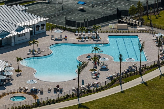 community pool with a patio and fence
