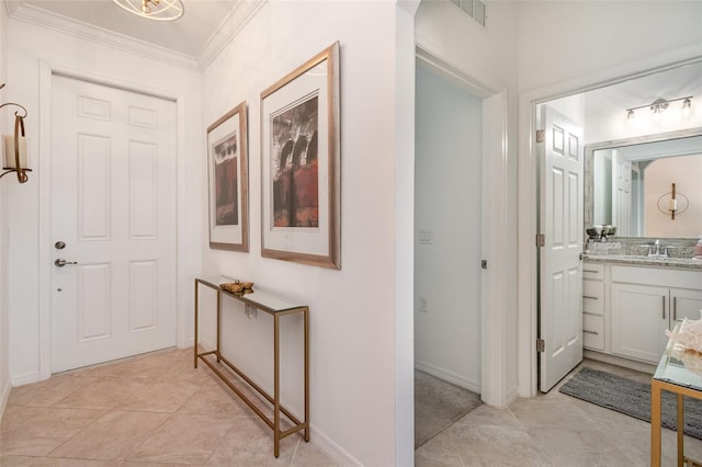 interior space with visible vents, ornamental molding, a sink, and light tile patterned flooring