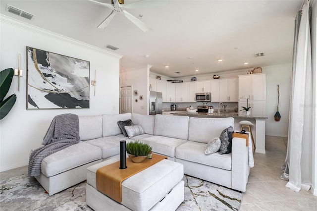 living room with visible vents, ornamental molding, and a ceiling fan