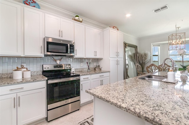 kitchen featuring visible vents, white cabinets, tasteful backsplash, a sink, and stainless steel appliances