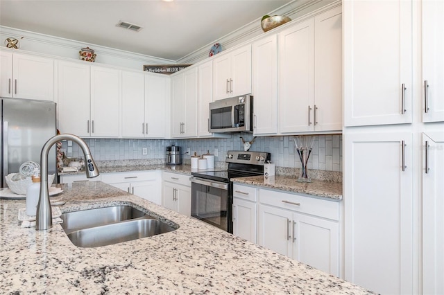 kitchen featuring a sink, appliances with stainless steel finishes, white cabinets, and visible vents