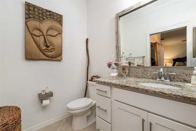 bathroom with crown molding, vanity, baseboards, and toilet