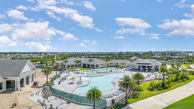 community pool with fence, a residential view, and a patio area